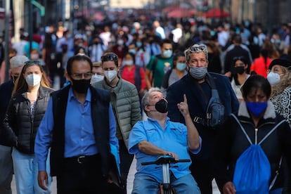 Personas con cubrebocas caminan por las calles del Centro Histórico, en Ciudad de México, en diciembre de 2021.