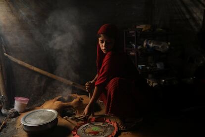 Shofika Begum cocina dentro de su vivienda temporal en el campo de refugiados de Kutupalong, cerca de Cox's Bazar (Bangladés).