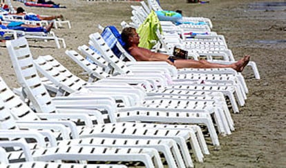 Un turista toma el sol en la playa D'en Bossa, de Ibiza.