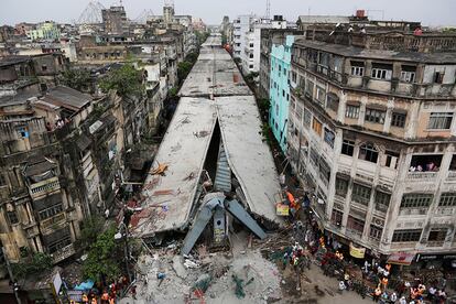Un pont a mig construir s'enfonsa a la ciutat de Calcuta (Índia), l'1 d'abril del 2016. La policia, els equips de rescat i els veïns col·laboren per intentar aixecar quilos de bigues i formigó.