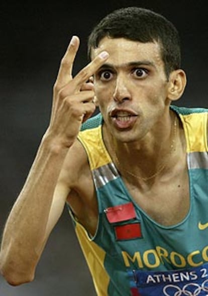El atleta marroquí Hicham el Guerruj, al hacer el doblete, como indican sus dedos, en el 1.500 y el 5.000.