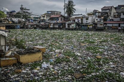 Los plástico, los jacintos de agua y la basura que cubren la superficie del río Estero de Vitas serán vertidos a la Bahía de Manila, a pocos kilómetros de distancia, y luego al mar del Sur de China. Tondo, Manila, Filipinas.