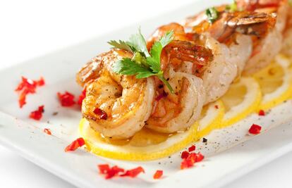 Gambas fritas sobre un 'carpaccio' de limón con salsa.