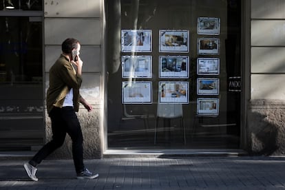 Un transeúnte camina por delante de una inmobiliaria en Barcelona.