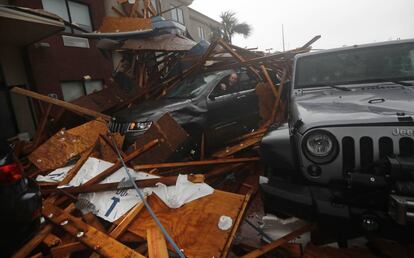 Un cazador de tormentas, en el interior de su vehículo, intenta recuperar parte de su equipo tras caer parte de la fachada de un edificio tras el paso del huracán Michael en Florida (EE UU), el 10 de octubre de 2018.