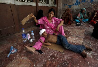 Una intensa ola de calor de más de tres días ha matado a cientos de personas en la provincia de Sindh, en el sur de Pakistán. En la imagen, una madre abanica a su hijo mientras espera para ser atendido en el Jinnah Postgraduate Medical Centre (CCPE) de la ciudad paquistaní de Karachi.