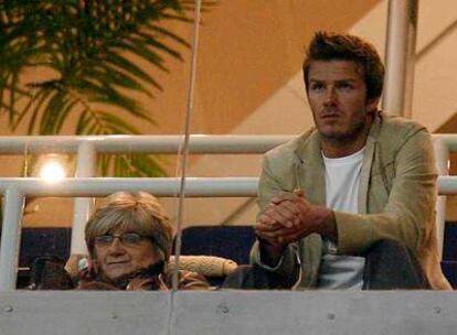 Beckham, en un palco junto a su madre, Sandra, observa el juego.