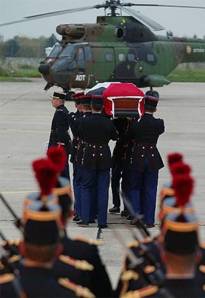 La guardia militar francesa porta el féretro de Arafat, cubierto con una bandera palestina, en la base aérea de Villacoublay.