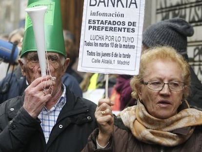 Dos ancianos con carteles proestan frente a la Audiencia Nacional.