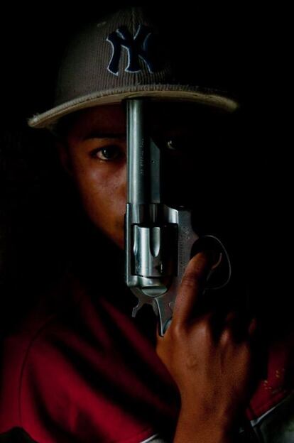 Un sicario posa con un revólver original de la policía colombiana.