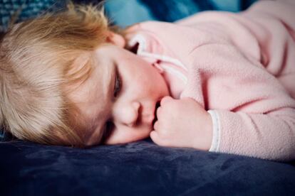 Un niño duerme plácidamente en su cama.
