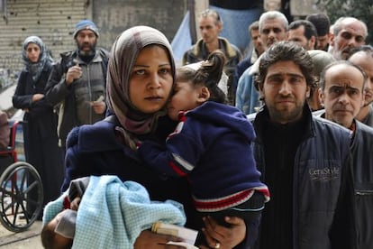 Refugiados del campo de Yarmuk guardan cola para recibir comida en marzo.