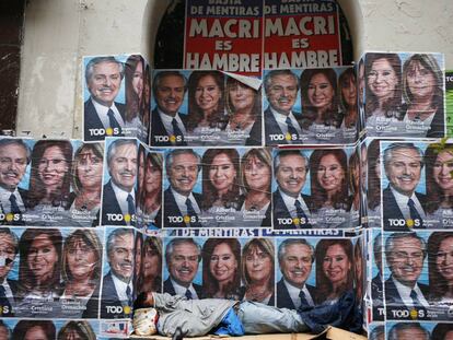 Un hombre duerme debajo de propaganda electoral, en Buenos Aires.