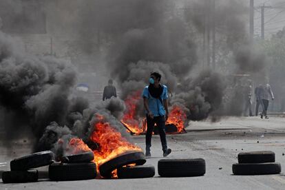 Un manifestante camina entre neumáticos en llamas durante una protesta contra las reformas del sistema de Seguridad Social en Managua (Nicaragua), el 20 de abril de 2018.