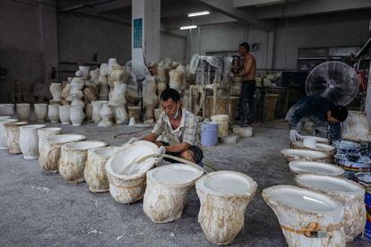 Trabajadores vierten látex líquido en los moldes de las máscaras de Donald Trump. 