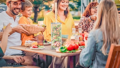 Una familia disfruta de una barbacoa con verduras a la parrilla.