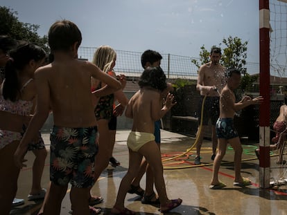 Un profesor refrescando a los alumnos en una escuela de Barcelona en junio, durante la ola de calor.