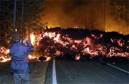 Una lengua de lava avanza por una carretera en las proximidades del Etna.