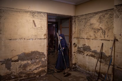 Una monja voluntaria ayuda en las tareas de limpieza de la casa de Maite Miravet en Paiporta, este martes. 