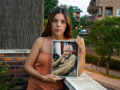 Nydia sujeta una foto de su abuelo, Mariano, fallecido el pasado enero, en su casa en Majadahonda, Madrid.