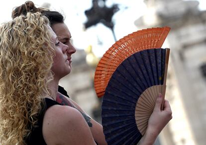 Dos mujeres se abanican frente al Palacio Real (Madrid). 