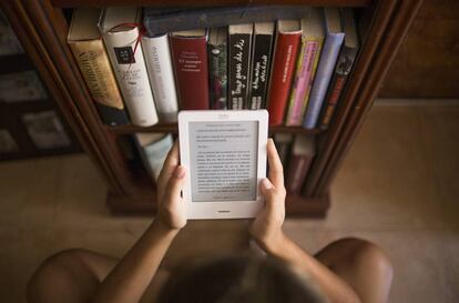 Una joven lee en un libro electrónico.
