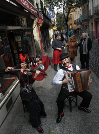 Los primeros sábados de cada mes, los tenderos de las Letras sacan sus productos a la calle y les añaden desde degustaciones a conciertos. En la foto, dos músicos de Desvariétés Orquestina en Casa González.