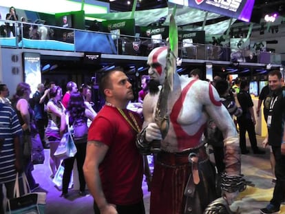 Un periodista posa con un modelo del personaje Kratos de 'God of war'.