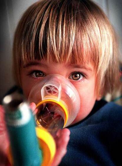 Una niña con asma se medica con inhaladores.