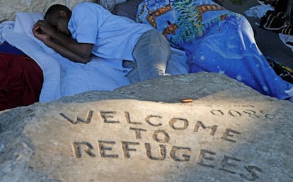 Dos migrantes sin hogar duermen en porte de la Chapelle, al norte de Par&iacute;s. 