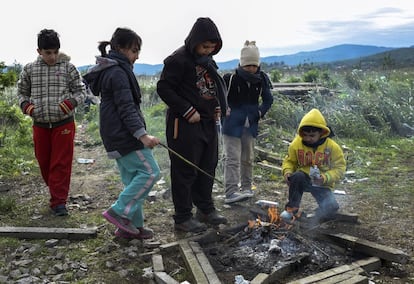 Varios niños se calientan junto a una hoguera tras cruzar la frontera entre Grecia y Macedonia, cerca de la ciudad de Gevgelija, Macedonia.