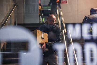 Algunos de los comerciantes afectados por la zona tapiada del mercado sacan el género de sus puestos.