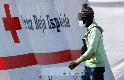 Un migrante camina hacia una carpa de la Cruz Roja después de desembarcar de un barco de la Guardia Costera española, en el puerto de Arguineguín, el pasado miércoles.