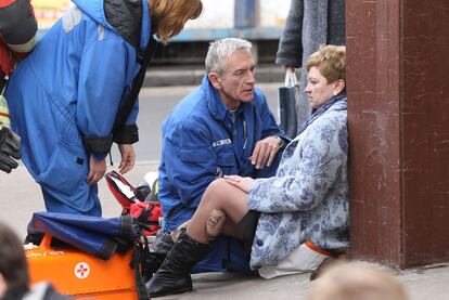 Un equipo médico atienden a una mujer en el exterior de la estación Park Kulturi.