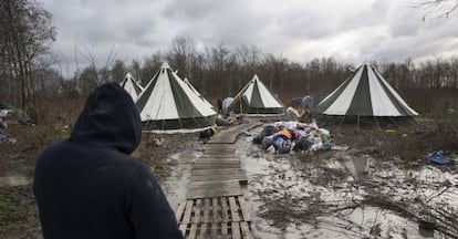 Un migrant camina cap a un dels habitatges del camp de Grande-Synthe (França).