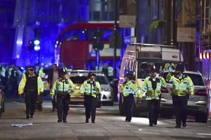 Un grupo de oficiales de policía vigilan en una calle cercana al Puente de Londres.