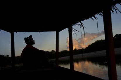 Un hombre disfruta del atardecer desde un bote en el río Purus, en Ucayali, Perú.