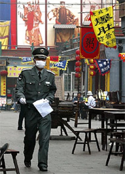 Un policía chino, en una calle de Pekín, casi vacía por la epidemia. 

/ ASSOCIATED PRESS