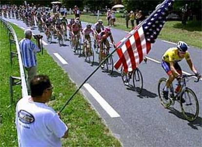 Un aficionado saluda ayer al paso del pelotón con una bandera de Estados Unidos.