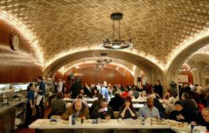 Un grupo de personas almuerzan en Oyster Bar en la Grand Central de Nueva York. La emblemática estación, que es uno de los sitios más visitados del mundo y tiene capacidad para millones de viajeros al año, celebra su 100 aniversario hoy.