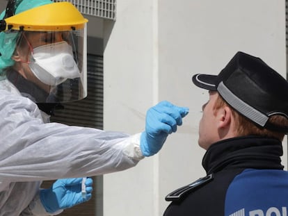 Una sanitaria realiza una prueba PCR a un policía local en Madrid.