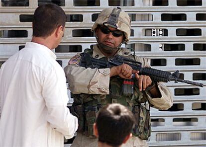 Un soldado estadounidense conversa con un joven iraquí en tanto patrulla por una calle de Falluja.