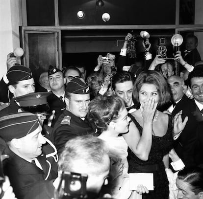 El 7 de mayo de 1962 la actriz italiana Sophia Loren, en el centro a la derecha, protegida por la policía a su llegada al Palacio del Festival de Cannes para la apertura del certamen.