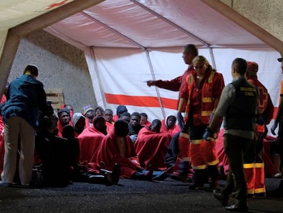 Miembros de la Cruz Roja y de la Guardia Civil atienden este jueves a un grupo de inmigrantes que ha llegado a Arguineguín (Gran Canaria).