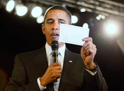 El presidente de EE UU, Barack Obama, recibe una nota con la noticia de la aprobación del plan en el Senado durante un mitin en Florida