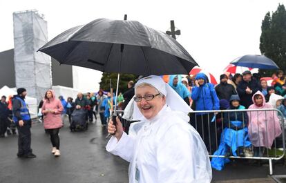 Una monja se protege de la lluvia mientras espera recibir al Papa, en Knock, el 26 de agosto de 2018. 