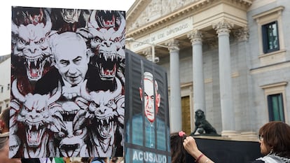 Un grupo de personas protesta con pancartas contra Benjamín Netanyahu en una concentración propalestina frente al Congreso de los Diputados, este jueves.