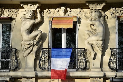 Un bandera colgada en un balcon de un apartamento de París.