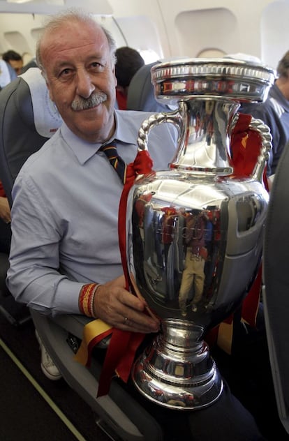 El seleccionador español, Vicente del Bosque, posa con la copa de campeones de la Eurocopa 2012, en el avión que trasladó al equipo español desde Kiev a Madrid.