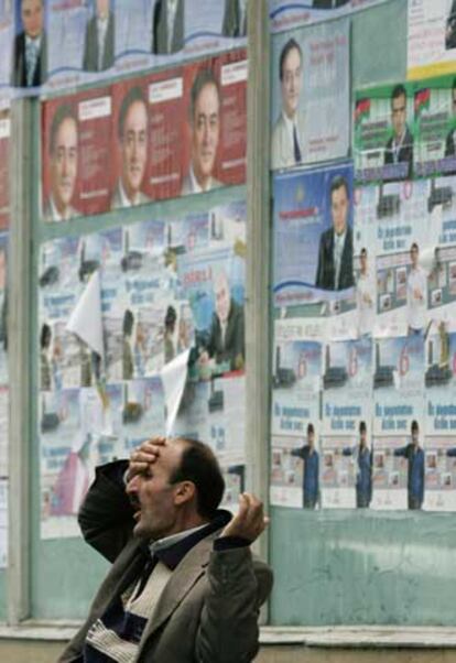 Un hombre gesticula ante propaganda electoral en Bakú.